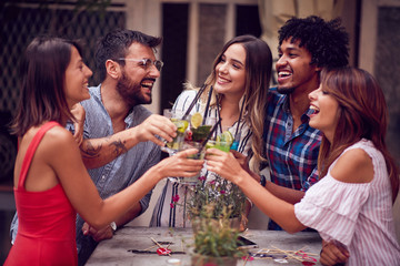 Group of young people with cocktails  having fun in nightclub celebrating. Fun, friendship,...