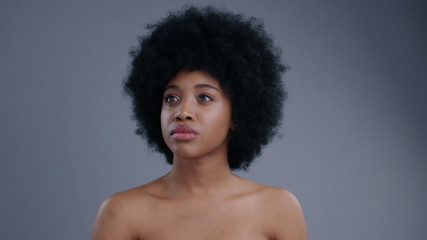 Fototapeta na wymiar Amazing half-naked african american woman tapping on future technology touchscreen choosing options. Portrait of lovely smart girl on grey background.