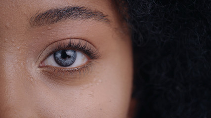 Close-up of beautiful african young woman face with cool digital eye with micro chips inside. Macro...