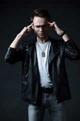 Obraz premium pensive stylish brutal man in biker jacket isolated on black