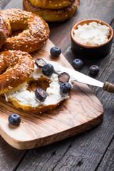 Bagels sandwich with cream cheese and blueberry on wooden table