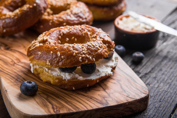 Bagels sandwich with cream cheese and blueberry on wooden table