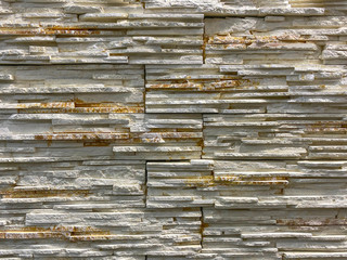 Detail of a wall from a decorative tile for decoration of buildings, interior. Artificial stone. Background, texture