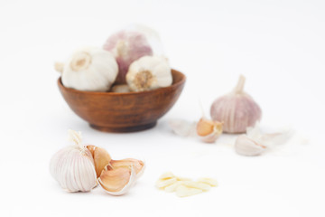 Organic garlic in wooden bowl on white background. Healthy vegetable..