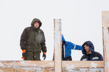 Two workers in overalls at a construction site