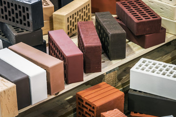 clinker, silicate, ceramic and other types of bricks of different colors. The background is of a...