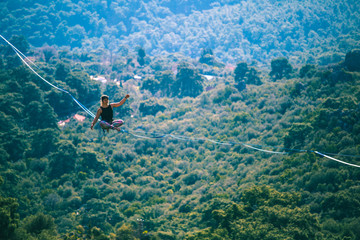 A woman sits on a stretched sling.