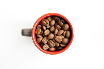 Small red espresso cup full of fresh roasted coffee beans on white background, top view