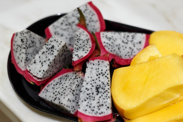 Large ripe pieces of juicy fresh mango and pitahaya. Useful and exotic fruits. The concept of a healthy diet and a healthy lifestyle. Superfoods. Dragon fruit or pitahaya