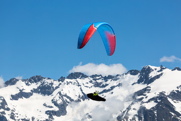 Paraglider with blue sky, clouds and mointains in background