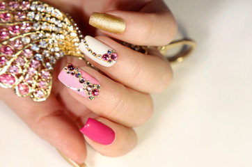A luxurious manicure with a pink matte finish for nails and a gradient from white with gold to pink...