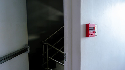 Red fire alarm switch at wall inside the building.