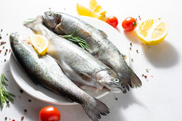 Fresh river trout with spices and vegetables on the table top view. Healthy and organic food concept.