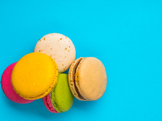 Colorful and tasty French Macarons on blue background.Top view.
