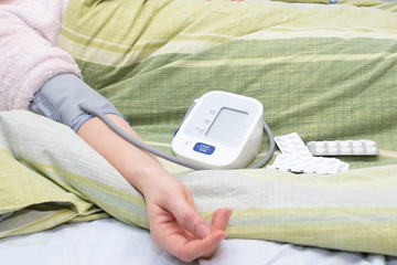 Tonometer, measuring blood pressure. Girl's hand on the bed. Diagnosis of hypertension and tachycardia.