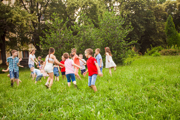 Obraz premium Kids playing funny games in a park in summer time