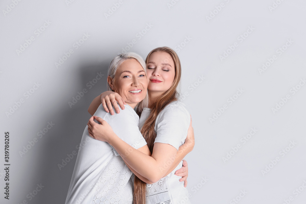 Poster Mother and her adult daughter on white background. Space for text