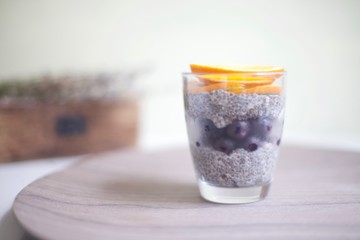 Homemade vegan Chia seed pudding with frozen blueberries and plat based cream on top
