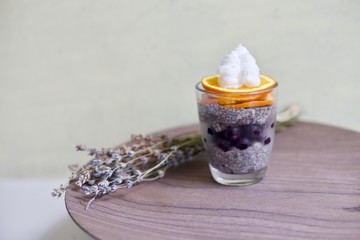 Homemade vegan Chia seed pudding with frozen blueberries and plat based cream on top