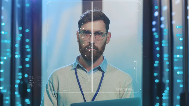 Future. Face ID. High Tech Biometric Facial Recognition. Technological 3D Face Scanning of Bearded IT Administrator with Laptop Working at Data Center Secure Storage. Augmented Reality.