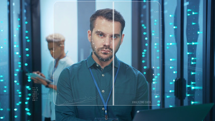 Face ID. Technological Face Detection with 3D Animation. Biometric Future Scanning of Face of Male IT Specialist Working with Laptop in Server Room Data Center. Augmented Reality. Cyber Security and