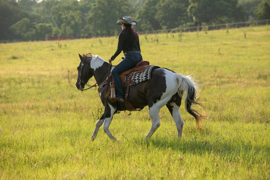 cowgirl riding paint horse