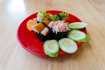 Rice Sushi is a lump of meat on red plate put on wood table  and eaten with sauce in Japanese food restaurant is a popular dish in Thailand  