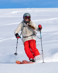 Girl On the Ski. a skier in a bright suit and outfit with long pigtails on her head rides outside...