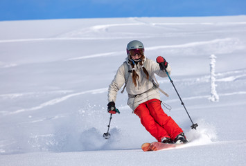 Girl On the Ski. a skier in a bright suit and outfit with long pigtails on her head rides outside...