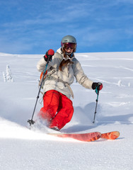 Girl On the Ski. a skier in a bright suit and outfit with long pigtails on her head rides outside...