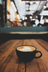 Coffee cup on wooden table bokeh background