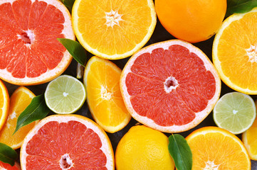 Fresh ripe sweet citrus fruits colorful bright background: orange, red grapefruit, green lime, yellow lemon