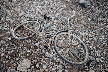 An old Bicycle abandoned on a shingle beach. Old bike with rust.