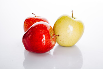 Red and yellow apples on white background with beautiful reflection