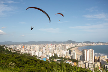 Fototapeta na wymiar Paragliders flying over the city of Santos and Sao Vicente