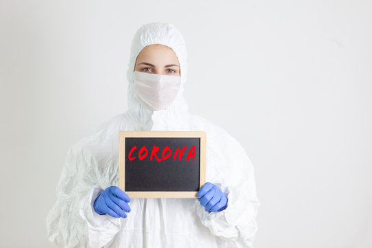 Person With Mask And Protective Clothing Holding A Blackboard, Corona Theme