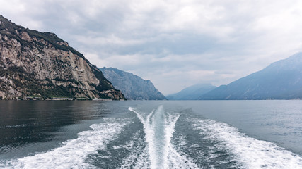 The trail of the boat on the sea. Sea with mountains in the background