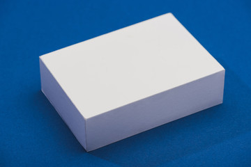 High angle view of white stand with shadow on blue background
