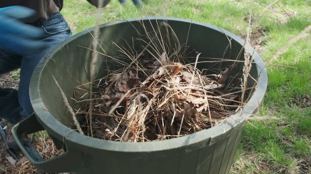 Dumping Spring Garden Waste in Trash Can. 4K