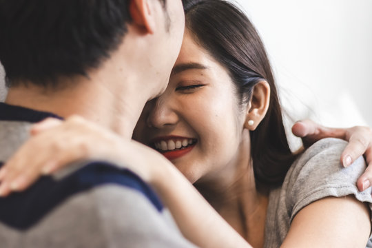 Lovely attractive young Asian couple man kiss forehead of happy woman with and hug in romantic moment. Warm heart marriage and lover bonding and relationship. Husband and wife in love photo concept.