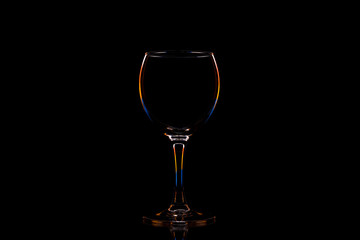 Glass with contour multicolored light on a black background with space for text.