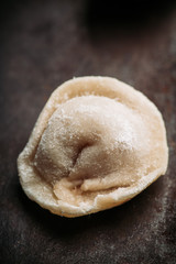 Fototapeta na wymiar Raw dumplings in flour on the table. Russian national food. Selective focus.