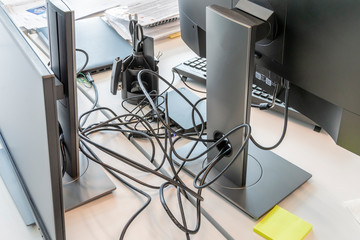 Clutter in office on the table. Unwound and tangled electrical computer wires. 5S system of lean...