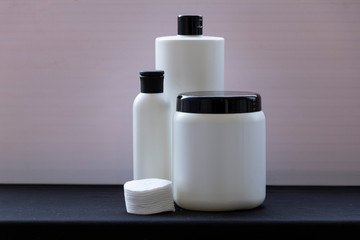 Mockup. White bottles for shampoo and masks for hair or other beauty items. on a black and white background. With a black cover. Red ribbon and heart, and gift.
