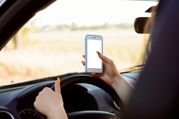 Mobile phone in hands of a female driver while being in intensive rush on road. Dangerous driving because of using mobile phone inappropriate time