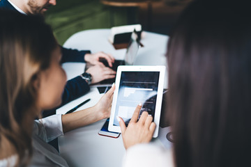Group of colleagues working with charts on tablet in office