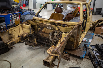 Fototapeta premium a garage there is a disassembled old car wreck to be restored