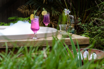 Romantic drink and bath tub in tropical garden
