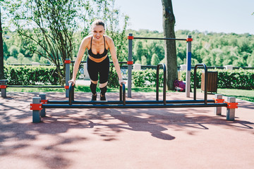 Glad sport female doing plank exercise in fresh air