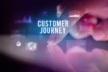 Finger touching tablet with charts and CUSTOMER JOURNEY inscription, business concept